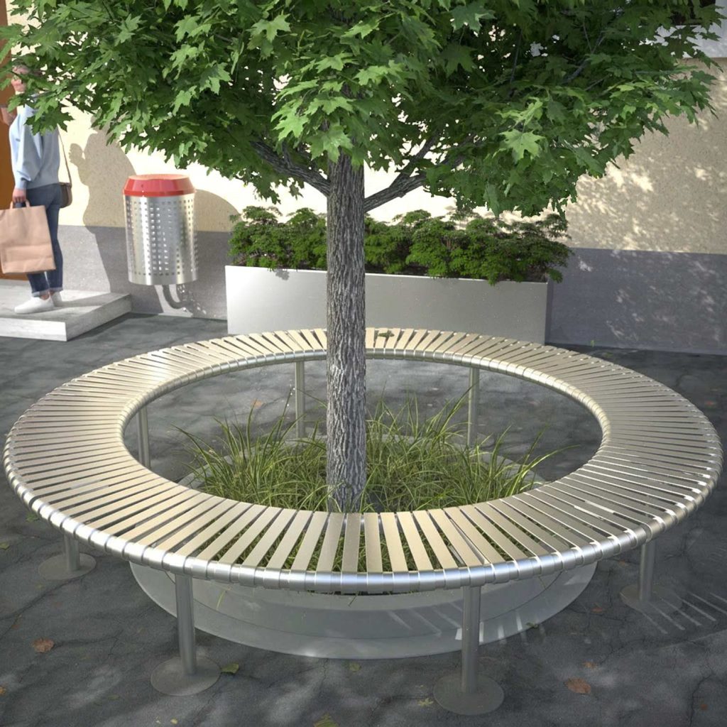 A circular stainless steel tree seat surrounds a lush, green tree in a streetscape.
