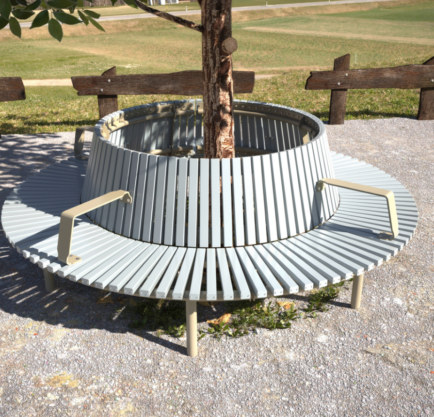 A circular metal tree seat, set on gravel, encircles a young tree. There is a park in the backdrop.