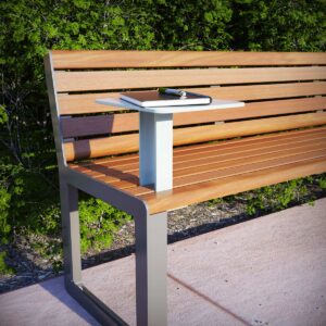 Small satellite table accessory on public seat in front of bushes