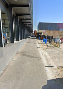 Alleyway with shopping centre on left had side, assorted buildings on the right